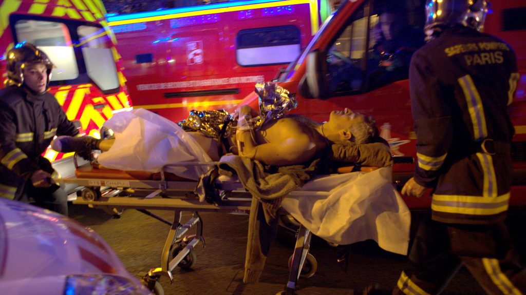 Sebesültet visznek a mentőautóhoz a Bataclan koncertterem közelében 2015. november 13-án, a Párizsban végrehajtott iszlámista terrorcselekmények éjszakáján (Fotó: MTI/EPA/Julien Warnand)