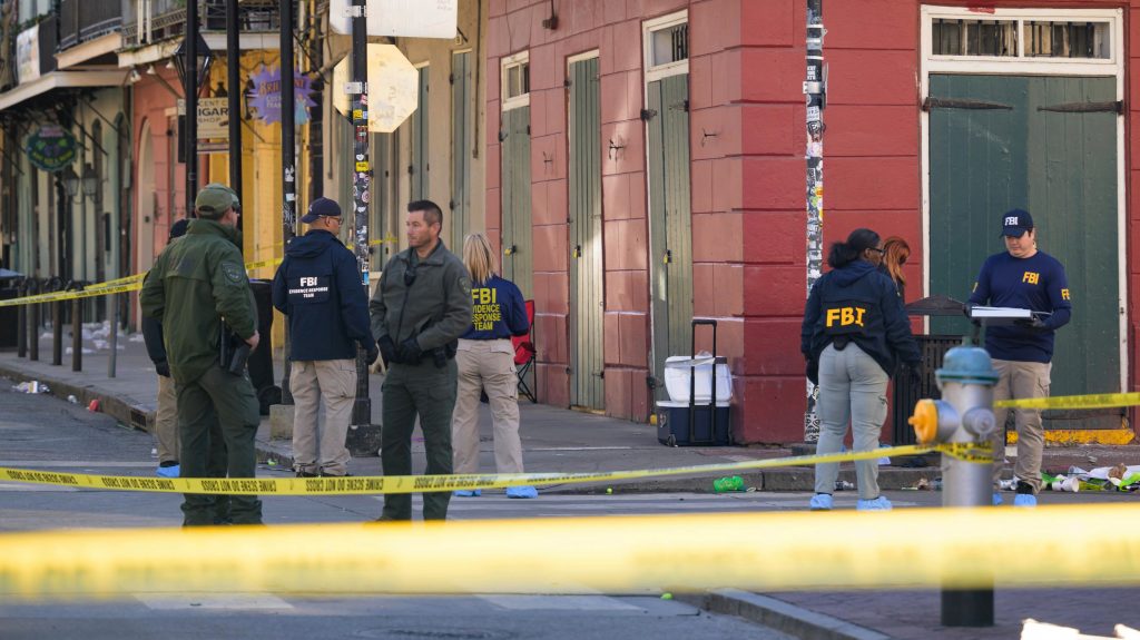 Az amerikai Szövetségi Nyomozóiroda (FBI) dolgozói vizsgálnak egy helyszínt, miután korábban egy autó belehajtott az ünneplő tömegbe a Louisana állambeli New Orleans egyik népszerű főutcájában (Fotó: MTI/AP/Matthew Hinton)