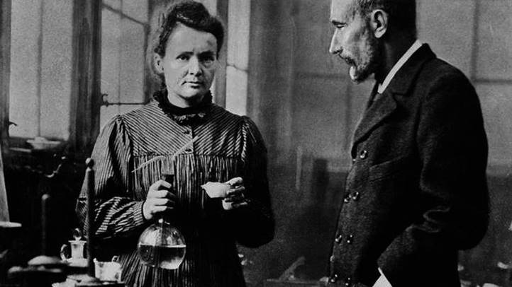 Marie Curie a kezében lombikot tart, mellette férje, Pierre Curie (Fotó: wikipedia.org)