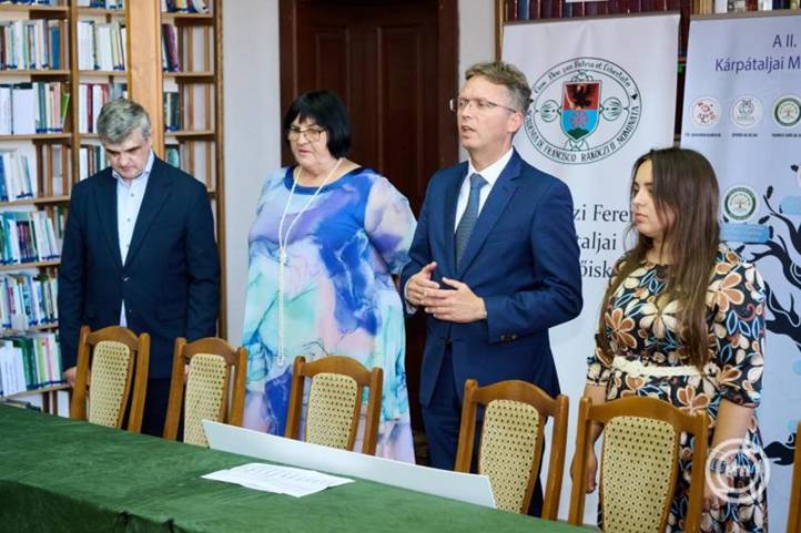 Hankó Balázs kultúráért és innovációért felelős miniszter (j2) beszédet mond, amikor átadja a Gödöllőn augusztus 21-én, az István, a király című rockopera koncertelőadásán összegyűjtött több mint 10 millió forintos adományt Tóth Tündének, a Kárpátaljai Magyar Főiskoláért Jótékonysági Alapítvány igazgatójának (j), Orosz Ildikónak, a Rákóczi-főiskola és a Kárpátaljai Magyar Pedagógusszövetség elnökének (b2) és Csernicskó István rektornak (b) a beregszászi II. Rákóczi Ferenc Kárpátaljai Magyar Főiskolán 2025. szeptember 21-én. Beregszász testvérvárosa Gödöllő. MTI/KIM/Bartos Gyula