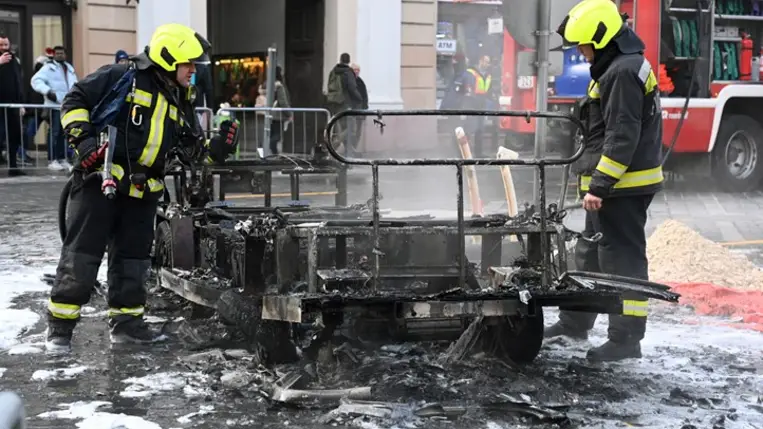 Kiégett elektromos városnéző kisbusz oltásának utómunkálatain dolgoznak tűzoltók a főváros I. kerületében, a budavári Dísz téren 2023. december 11-én. MTI/Mihádák Zoltán