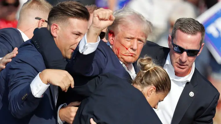 Donald Trump volt amerikai elnököt, a Republikánus Párt elnökjelöltjét (k) a védelmét ellátó titkosszolgálat ügynökei veszik körbe a Pennsylvania állambeli Butlerben rendezett kampánygyűlésen 2024. július 13-án.Fotó: MTI/AP/Gene J. Puskar