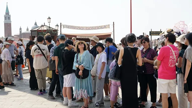  Látogatók egy csoportja várja, hogy a városi rendőrség megérkezzen, és bírságot szabjon ki a turisták csoportjait érintő új intézkedések közepette a velencei Piazzetta San Marco téren, Olaszországban, 2024. augusztus 01-én. (Fotó: EPA/ Andrea Merola)