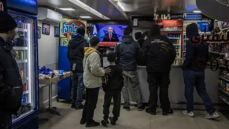  Emberek nézik a televíziót egy óvóhelyen, amint Benjamin Netanjahu miniszterelnök kihirdeti tűzszünetet Libanonnal 2024. november 26-án. (Fotó: Ed Ram/Getty Images)