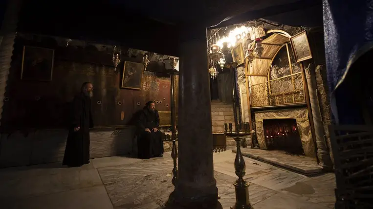 Papok imádkoznak a Jézus Krisztus születése helyét jelző 14-ágú ezüstcsillag közelében, a betlehemi Születés Templomának altemplomában 2020. december 23-án. (Fotó: MTI/EPA/Atef Szafadi)