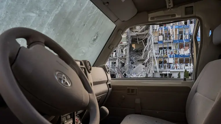 Az aknamentesítésre szakosodott svájci FSD nonprofit szervezet súlyosan megrongálódott székháza egy orosz légicsapást követően egy szilánkokkal teli autó utasterén keresztül nézve a kelet-ukrajnai Harkivban 2024. július 24-én.Fotó: MTI/EPA/Szergej Kozlov