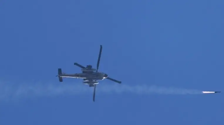  Észak-Izrael fölött repülő izraeli Apache helikopter rakétát lő ki Dél-Libanonra 2024. október 4-én (Fotó: MTI/EPA/Atef Szafadi).