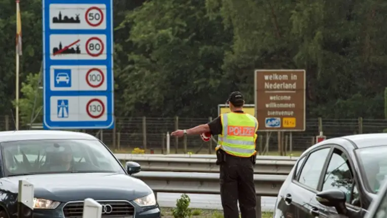 Egy német rendőrtiszt ellenőrzi a Hollandiából érkező járműveket az A30-as autópályán Bad Bentheim közelében (Fotó: Ingo Wagner/Picture Alliance/Getty Images)