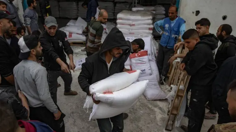 Liszteszsákokat vesznek át palesztin belföldi menekültek egy humanitárius elosztóponton Gáza városában 2025. április 1-jén az ENSZ Világélelmezési Programjának keretében. (Fotó: MTI/EPA/Haiszam Imad)