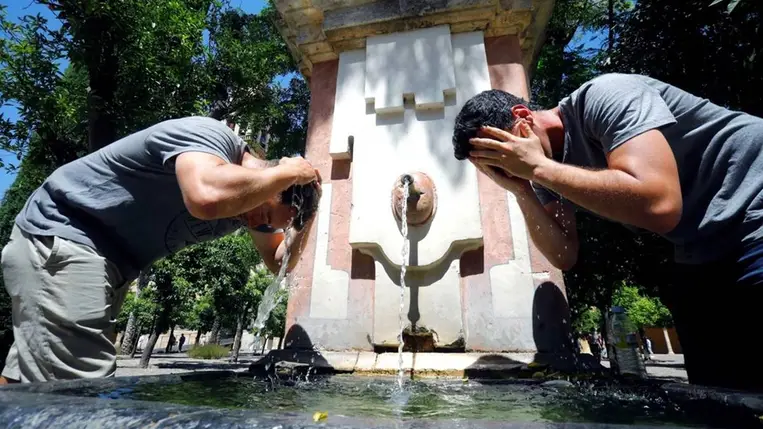 Turisták hűsítik magukat egy szökőkút vizében (Fotó: MTI/EPA-EFE/Salas)