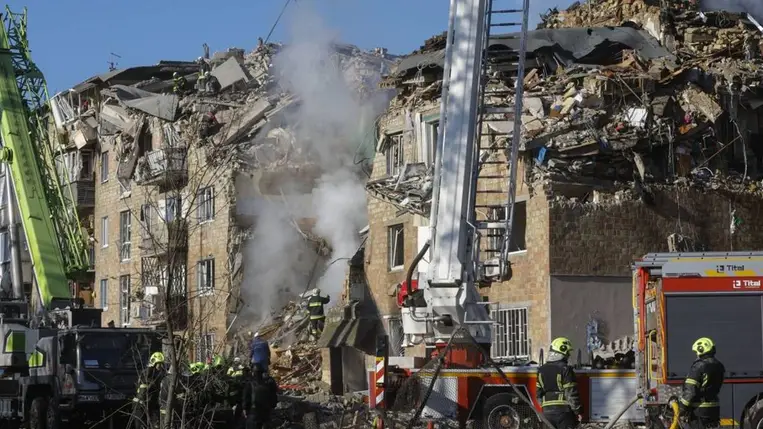  Tűzoltók dolgoznak egy orosz rakétatámadásban megsemmisült lakóház romjai között Kijevben (Fotó: MTI/EPA/Szerhij Dolzsenko)