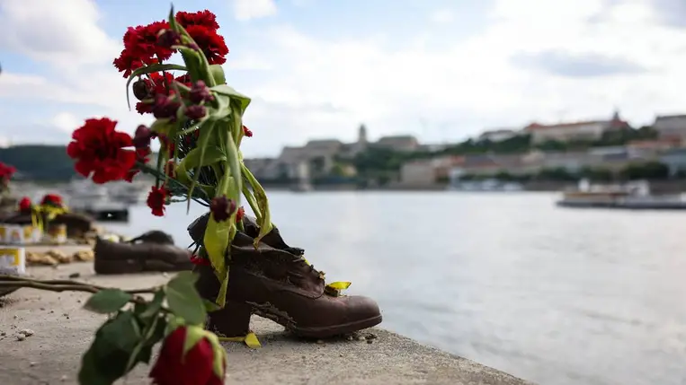 Az élet menete résztvevői által elhelyezett virágok a budapesti Cipők a Duna-parton holokauszt-emlékműnél 2025. május 11 (Fotó: MTI/Hegedüs Róbert)