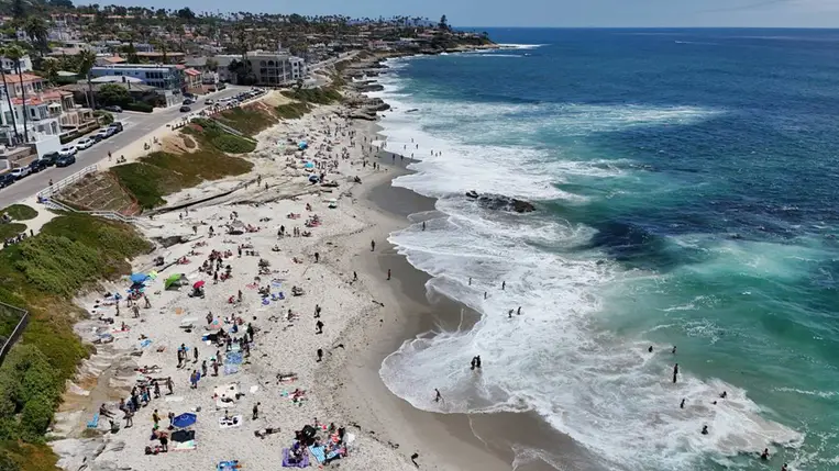 Légi felvételen látható, ahogy az emberek napoznak a strandon, miközben a hullámok megtörnek a La Jolla-i Windansea Beach partvonalán 2026. június 20-án. Fotó: Kevin Carter / Getty Images