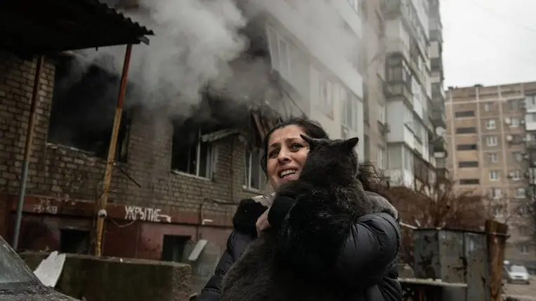 Ölben viszi a macskáját egy nõ egy ukrán rakétatámadásban súlyosan megrongálódott lakóház elõtt a kelet-ukrajnai Donyeckben 2023. december 19-én (Fotó: MTI/EPA/Valerij Melnyikov)