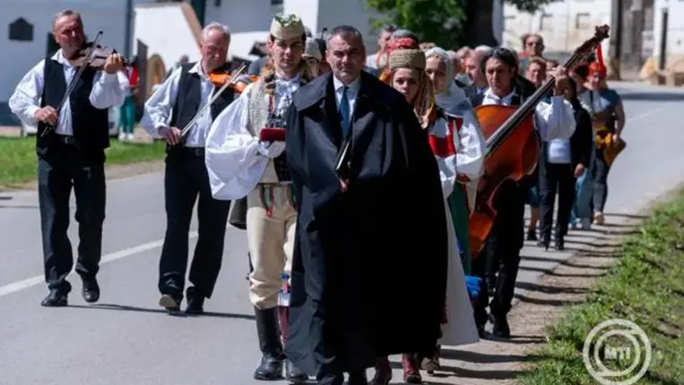 Népviseletbe öltözött fiatalok és népzenészek kíséretében vonul Csécs Márton Lőrincz lelkipásztor a Szent Korona másolatának kíséretében a Duna Háztól az unitárius templomba a torockói Duna Napokon 2025. június 1-jén. Idén 11. alkalommal rendezik meg a programsorozatot, amelynek fókuszában a néptánc, a népzene, a népi kultúra áll. MTI/Kiss Gábor
