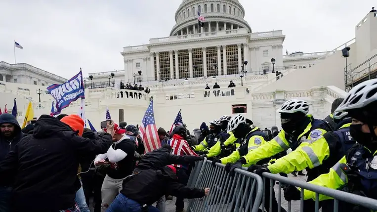 Donald Trump republikánus párti amerikai elnök támogatóinak egy csoportja a rendőrkordont áttörve megrpóbál behatolni az amerikai törvényhozás washingtoni épületébe, a Capitoliumba 2021. január 6-án. MTI/AP/Julio Cortez.