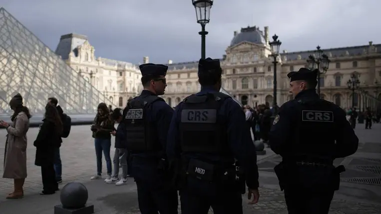 Járőröző rendőrök, mögöttük a párizsi Louvre múzeum bejáratánál állnak sorban érdeklődők 2025. október 27-én. (Fotó: MTI/AP/Christophe Ena)