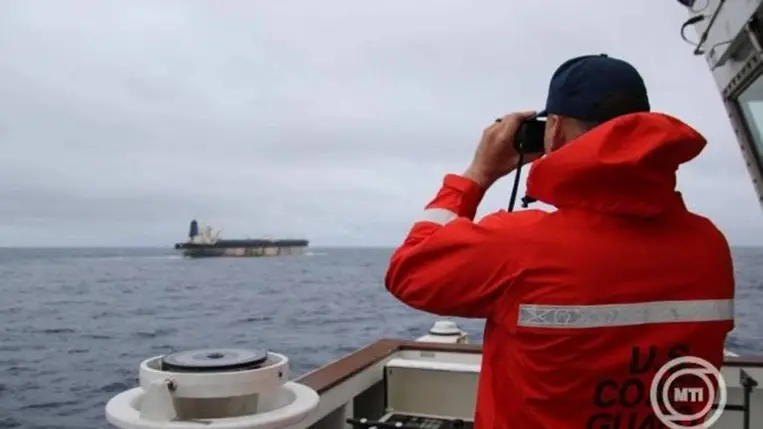 2026. január 7. A parti őrség egyik tagja távcsővel figyeli a The Marinera tartályhajót egy meg nem nevezett helyszínen. MTI/EPA/EUCOM