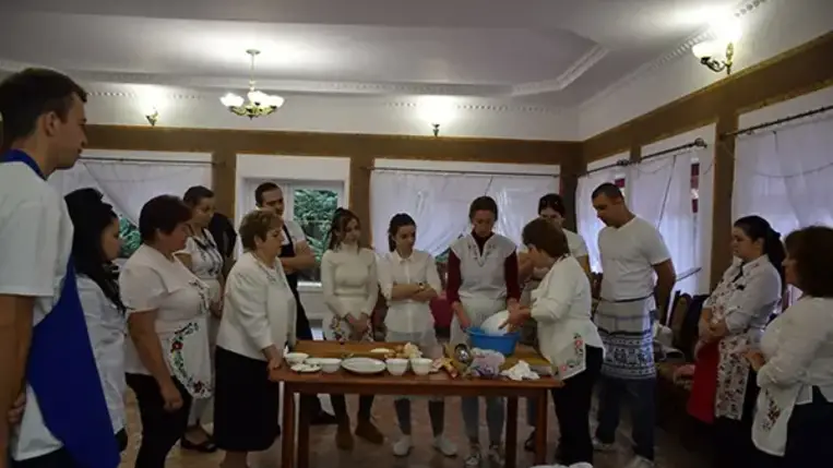 Homoki Szilvia, aki a falusi vendéglátással szülőfalujában, Beregdédában már két évtizeddel ezelőtt kezdett foglalkozni, ezúttal a csörögének való tésztát gyúrja be, miközben a tanfolyam hallgatói körbe állják.