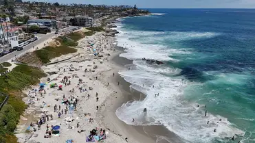 Légi felvételen látható, ahogy az emberek napoznak a strandon, miközben a hullámok megtörnek a La Jolla-i Windansea Beach partvonalán 2026. június 20-án. Fotó: Kevin Carter / Getty Images