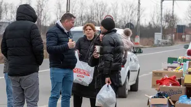 Egy civil szervezet önkéntese segít tovább utazást szervezni az orosz-ukrán háború elől Ukrajnából menekülő családnak a halmi román-ukrán határátkelőhely román oldalán 2022. március 7-én. (Fotó: Kiss Gábor/MTI/MTVA)