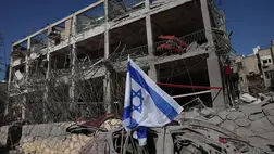 Romos lakóház előtti autóroncsba tűzött izraeli zászló Ramat Ganban 2025. június 14-én, miután iráni rakétatámadás érte a közép-izraeli várost (Fotó: MTI/EPA/Abir Szultan)