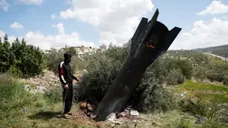 Egy személy áll a földbe szorulva talált rakétamaradványok mellett Kifl Haris faluban, Nablus közelében 2026. március 24-én. Fotó: Mohamad Torokman / Reuters