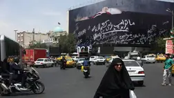 Egy nő elsétál egy Donald Trump amerikai elnököt koporsóban ábrázoló óriásplakát mellett Teheránban 2026. július 18-án. Fotó: Majid Asgaripour / WANA (West Asia News Agency) / Reuters