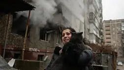 Ölben viszi a macskáját egy nõ egy ukrán rakétatámadásban súlyosan megrongálódott lakóház elõtt a kelet-ukrajnai Donyeckben 2023. december 19-én (Fotó: MTI/EPA/Valerij Melnyikov)