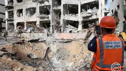 Mentőalakulatok tagjai és katonák egy iráni légicsapásban megsemmisült épület előtt Tel-Avivban 2026. március elsején.  MTI/EPA/Abir Szultan