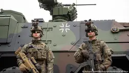 Német katonák felfegyverkezve egy harckocsi előtt