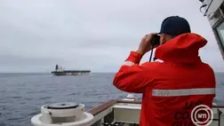 2026. január 7. A parti őrség egyik tagja távcsővel figyeli a The Marinera tartályhajót egy meg nem nevezett helyszínen. MTI/EPA/EUCOM