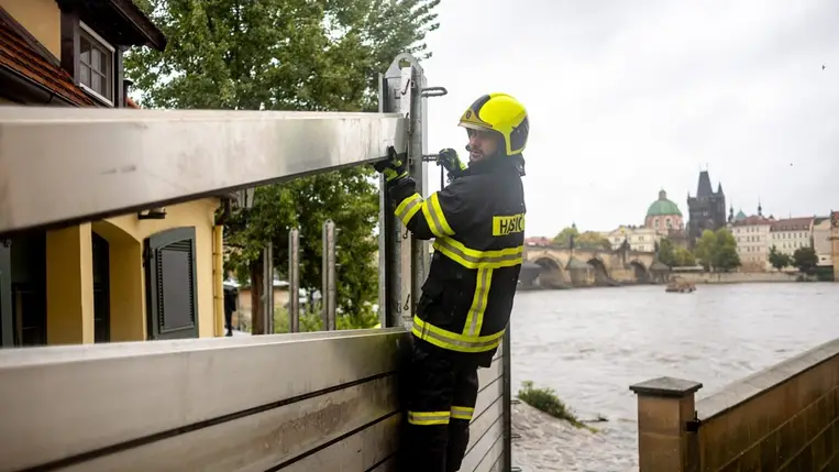 Árvízvédelmi mobilgátat emelnek tűzoltók a Moldva folyó partján, Prága belvárosában 2024. szeptember 13-án. A Cseh Hidrometeorológiai Intézet, a CHMU az országos esőzés miatt a folyók szintjének jelentős emelkedésére figyelmeztetett (Fotó: MTI/EPA/Martin Divisek)