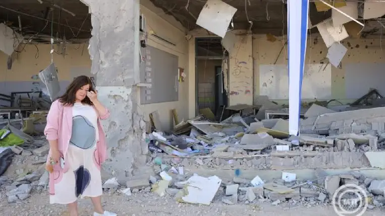 Chani Karinel igazgató nézi az iráni rakétatámadásban súlyosan megrongálódott iskolaépületet a dél-izraeli Gedera városban 2024. október 2-án.  MTI/EPA/Abir Szultan