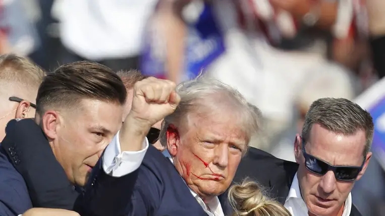 Donald Trump az ellene elkövetett merényletkísérletet követően a Pennsylvania állambeli Butler-ben 2024. július 13-án, ahogy ökölbe szorított kezét a levegőbe emelve nyugtatja meg támogatóit. Fotó: EPA/DAVID MAXWELL