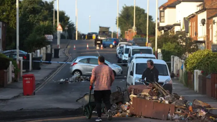 Az előző esti zavargások során keletkezett törmeléket távolítják el munkások az északnyugat-angliai Southportban 2024. július 31-én, miután nacionalista tüntetők és rendőrök csaptak össze a két nappal korábbi késelés helyszínén.  (Fotó: MTI/EPA/Adam Vaughan)