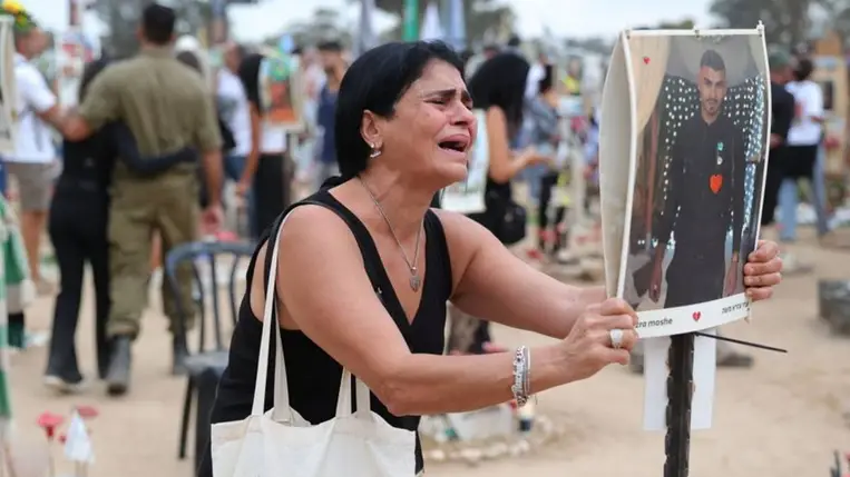 A 2023. október 7-én megölt emberek hozzátartozói megemlékeznek az áldozatokról a Hamász palesztin iszlamista szervezet fegyveresei által elkövetett vérengzés első évfordulójának alkalmából a támadás színhelyén (Fotó: MTI/EPA/Abir Szultan)