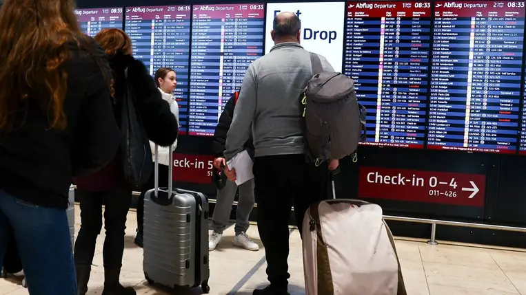  A menetrendet nézik utasok a Berlin-Brandenburgi repülőtéren (Fotó: MTI/EPA/Filip Singer)