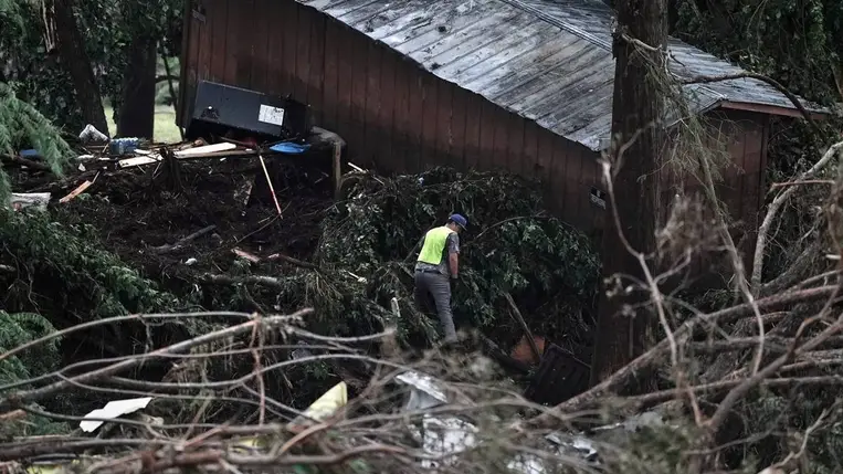 Mentőcsapatok tagjai egy elsodort épületet kutatnak át a megáradt Guadalupe folyó partján, a texasi Huntban 2025. július 6-án (Fotó: MTI/EPA/Dustin Safranek)
